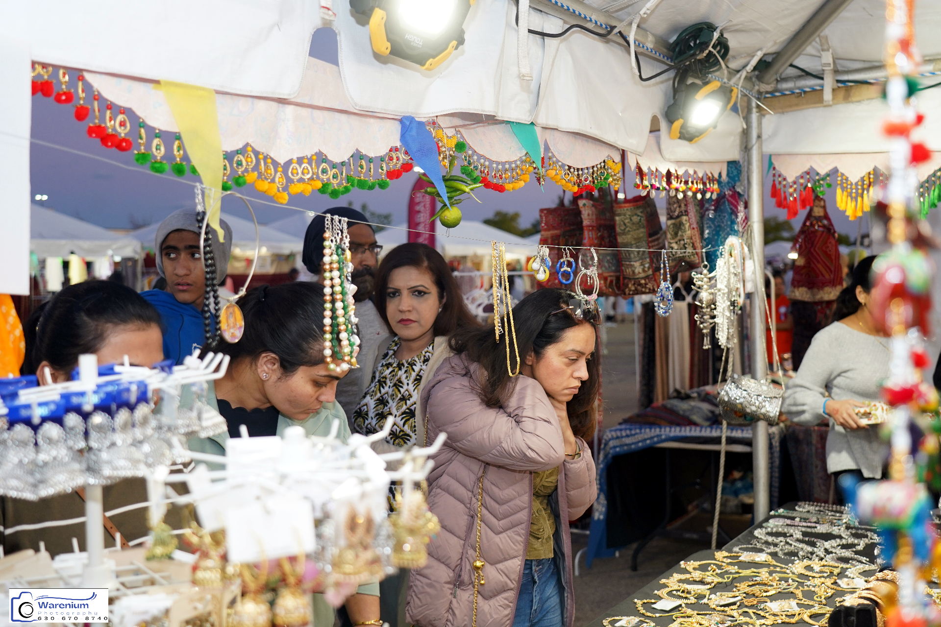 Shoppers browsing jewelry and crafts at the Day 4 bazaar stall