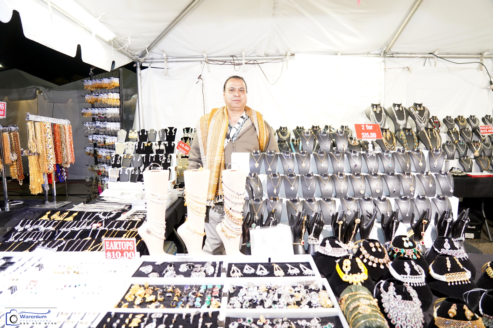 Jewelry vendor display shining under the Day 4 bazaar tent