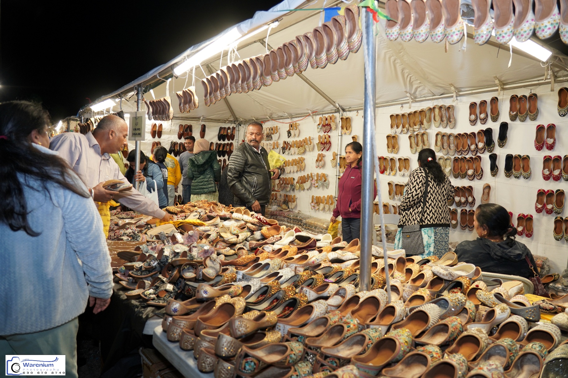 Crowded Day 4 jutti stall lined with embroidered footwear and shoppers
