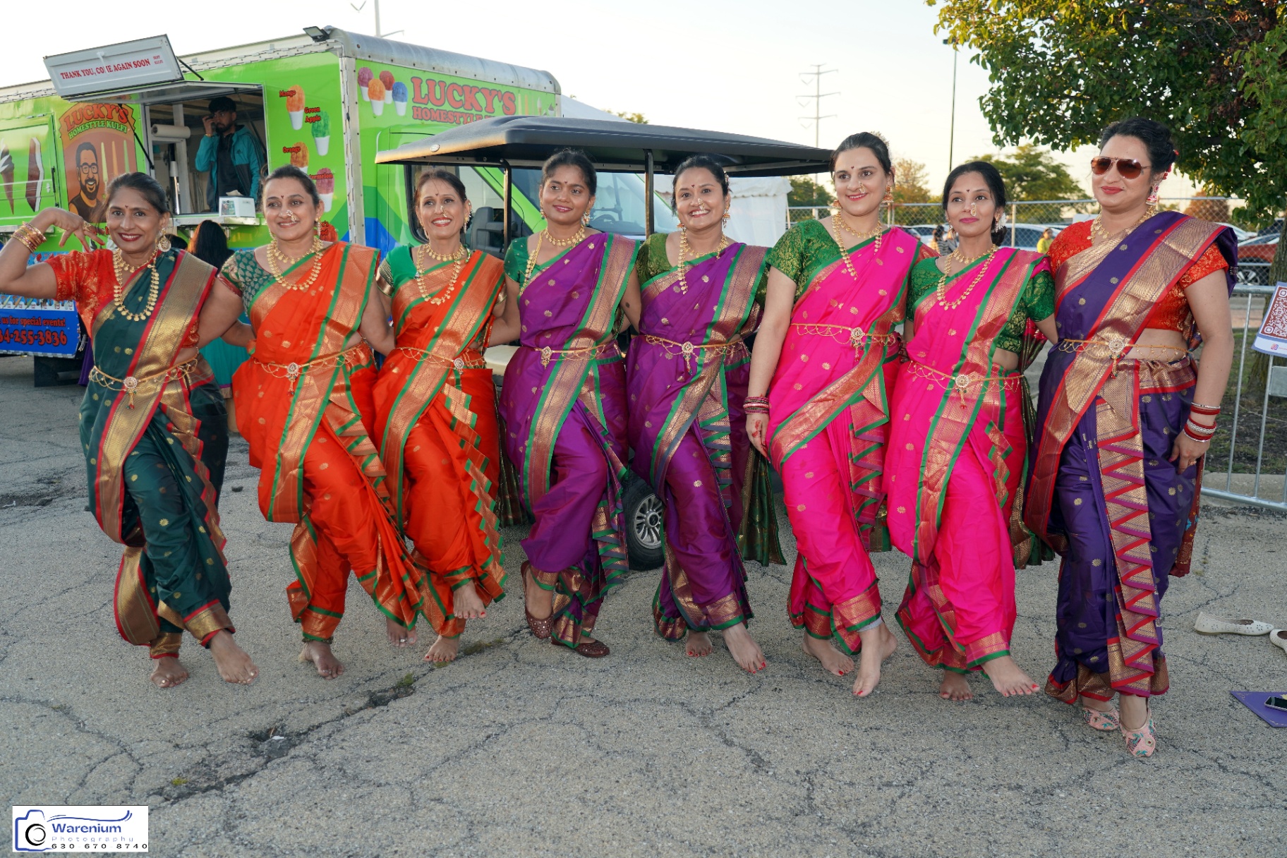Day 4 cultural group posing in colorful sarees near the festival grounds
